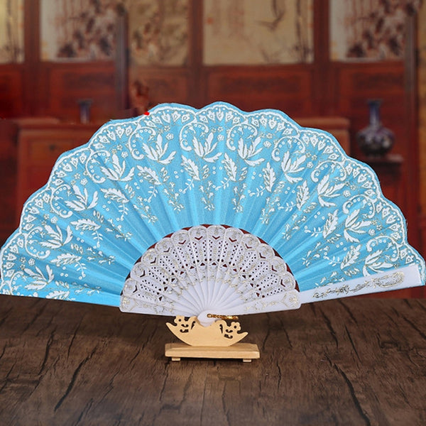 Chinese-style folding fan with floral designs, ideal for cooling and decorative purposes. Comes with a fabric sleeve.