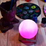 Pink moon night lamp with wooden stand, perfect for bedroom.